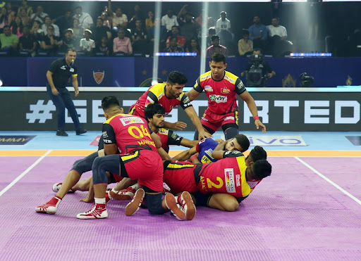 Bengaluru Bulls' players pin down a U Mumba player, Shiv Om, in